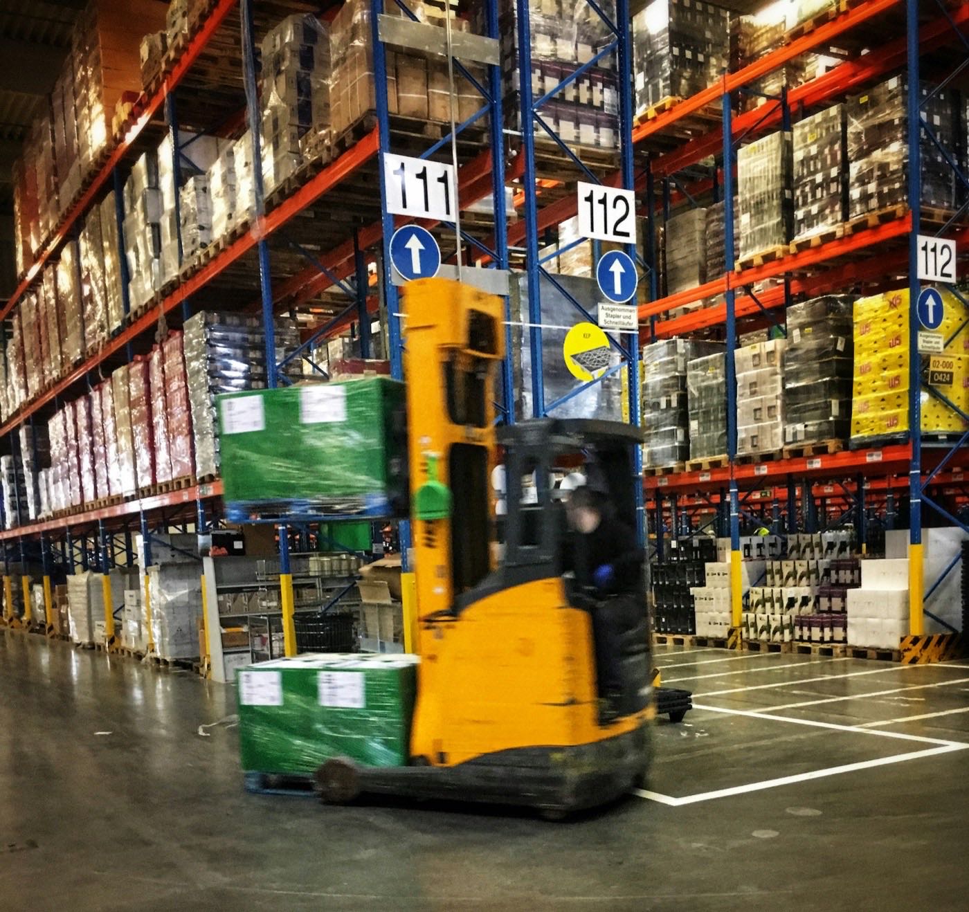 Reach truck handling pallets in a distribution warehouse